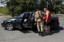 A Ukrainian serviceman checks a car at a checkpoint near the eastern Ukrainian town of Debaltseve