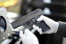 An LAPD officer inspects a handgun during a gun buyback program in Los Angeles, California