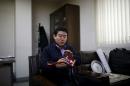 Seo Jae-pyoung, the secretary general of the association of the North Korean defectors, looks at a Workersâ€™ Party membership card holder while demonstrating the use of it during an interview with Reuters in Seoul