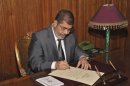 Egypt's President Mursi signs a decree to put into effect the new constitution in Cairo