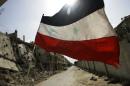 A Syrian flag flutters outside a military barrack in the devastated Baba Amr neighbourhood of Homs on May 2, 2012