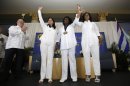 In this Friday, May 20, 2013 photo, Cuban dissidents Ladies in White, from left, Laura Labrada Pollan, Berta Soler, and Belkis Cantillo acknowledge the guests at the Freedom Tower in Miami. MDC President Dr. Eduardo J. Padron, far left, presented Soler with MDC's Presidential Medal in homage to all the Ladies in White engraved, "Guardians of Freedom." Ladies in White is a group of women that began marching peacefully after the arrests of their sons and husbands in a 2003 crackdown on dissidents. They have faced detention and violence from pro-government mobs. (AP Photo/Alan Diaz)