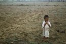 A boy, displaced by the recent violence in Pauktaw stands in the field near Owntaw refugee camp for Muslims outside Sittwe