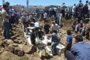 People gather at a mass burial for the victims purportedly killed during an artillery barrage from Syrian forces in Houla