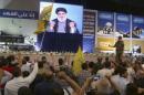Supporters of Lebanon's Hezbollah leader Sayyed Hassan Nasrallah gesture as he appears on a screen during a rally to mark "Quds Day" in Beirut's southern suburbs