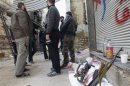 Free Syrian Army fighters stand by their weapons in the besieged area of Homs