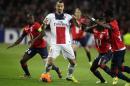 PSG's Zlatan Ibrahimovic, center, controls the ball during his French League one soccer match against Lille at the Lille Metropole stadium, in Villeneuve d'Ascq, northern France, Saturday, May 10, 2014. PSG has already won its second straight French league title. (AP Photo/Michel Spingler)
