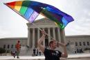 John Becker, 30, of Silver Spring, Md., waves a rainbow flag in support of gay marriage outside of the Supreme Court in Washington, Thursday June 25, 2015. The same-sex marriage ruling is among the remaining to be released before the term ends at the end of June. (AP Photo/Jacquelyn Martin)