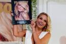 2015 Playmate of the Year, holds a plaque with the cover of the Playboy June 2015 issue at the Playboy Mansion in Los Angeles
