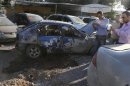 Residents inspect the remain of one of two rockets that hit residential area in Beirut suburbs