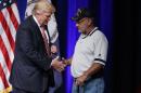 Republican presidential candidate Donald Trump shakes hands with Louis Dorfman, after Dorfman gave his Purple Heart medal to Trump during a campaign rally at Briar Woods High School, Tuesday, Aug. 2, 2016, in Ashburn, Va. (AP Photo/Evan Vucci)