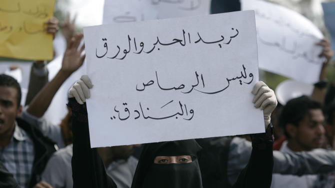 A student holds a banner with Arabic that reads, "we want ink and pens not bullets and rifles," to protest against the Shiite insurgency during a rally at the University of Sanaa, Yemen, Tuesday, Nov. 25, 2014. (AP Photo/Hani Mohammed)