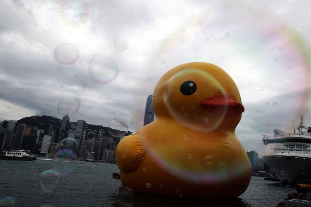 Bubbles created by machine fly in front of Rubber Duck by Dutch artist Hofman floats at Ocean Terminal at Hong Kong's Victoria Harbour