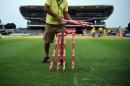 A man collects the stumps from the field after rain interrupted at the Kensington Oval stadium in Bridgetown