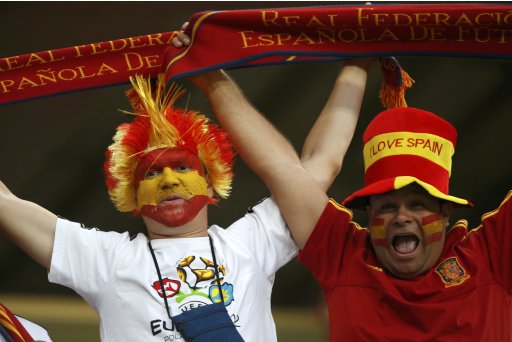 Spain soccer fans with their faces painted in colors of national flag cheer before Euro 2012 semi-final soccer match against Portugal at Donbass Arena in Donetsk