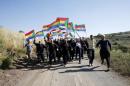 Members of the Druze community carry flags at they walk towards the border fence in Israeli-occupied Golan Heights