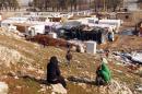 Syrian refugees take advantage of the sunshine after a storm at an unofficial refugee camp in Bar Elias, in Lebanon's Bekaa Valley, on January 26, 2016