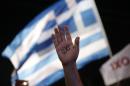 A demonstrator rises his hand reading the word ''No'' as a Greek flag waves during a rally organized by supporters of the No vote in Athens, Friday, July 3, 2015. A new opinion poll shows a dead heat in Greece's referendum campaign with just two days to go before Sunday's vote on whether Greeks should accept more austerity in return for bailout loans. (AP Photo/Petros Giannakouris)