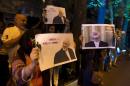 Iranians hold pictures of Iranian Foreign Minister Mohammad Javad Zarif as they celebrate in the street following a nuclear deal with major powers, in Tehran