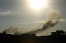 Smoke rises from buildings following an air strike attack early in the morning on August 27, 2014, near military camps in Libya's eastern coastal city of Benghazi