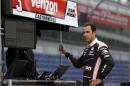 Helio Castroneves, of Brazil, watches practice from the pit area on the opening day at the Indianapolis Motor Speedway in Indianapolis, Sunday, May 3, 2015. (AP Photo/Michael Conroy)
