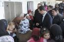 Syria's President Assad speaks with women during his visit to displaced Syrians in the town of Adra in the Damascus countryside