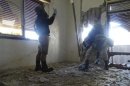 U.N. chemical weapons experts, wearing gas masks, inspect one of the sites of an alleged chemical weapons attack in the Damascus' suburb of Zamalka