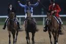 William Buick, middle, on UAE-owned Prince Bishop, celebrates after they won the $ 10,000,000 Dubai World Cup during the Dubai World Cup horse races at Meydan Racecourse in Dubai, United Arab Emirates, Saturday, March 28, 2015. (AP Photo/Kamran Jebreili)