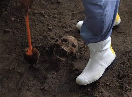 A police officer excavates a human skull at a construction site in the former war zone in Mannar