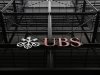 Signs are seen on the outside of Swiss bank UBS in central London