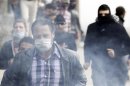 Protesters opposing Egyptian President Mursi are seen through tear gas fired by riot police during clashes along Qasr Al Nil bridge, which leads to Tahrir Square in Cairo