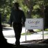 A man walks past a Google sign in Mountain View, Calif., Friday, June 7, 2013. Google CEO Larry Page is denying reports linking the Internet search company to a secret government program that has provided the National Security Agency access to email and other personal information transmitted on various online services. (AP Photo/Jeff Chiu)