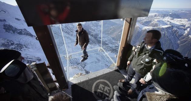 Journalists and employees stand in the &#39;Step into the Void&#39; installation at the Aiguille du Midi mountain peak above Chamonix, in the French Alps