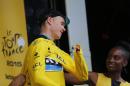 Britain's Chris Froome puts on the overall leader's yellow jersey on the podium of the fifteenth stage of the Tour de France cycling race over 183 kilometers (113.7 miles) with start in Mende and finish in Valence, France, Sunday, July 19, 2015. (AP Photo/Christophe Ena)