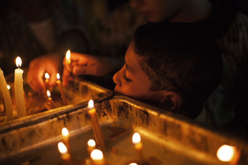 An Egyptian Coptic Christian child lights a candle in honor of the Virgin Mary at Al-Mahraq monastery in Assiut, Upper Egypt, Tuesday, Aug. 6, 2013. Islamists may be on the defensive in Cairo, but in Egypt's deep south they still have much sway and audacity: over the past week, they have stepped up a hate campaign against the area's Christians. Blaming the broader Coptic community for the July 3 coup that removed Islamist President Mohammed Morsi, Islamists have marked Christian homes, stores and churches with crosses and threatening graffiti. (AP Photo/Manu Brabo)