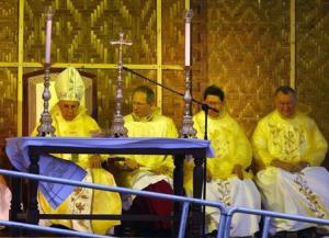 Pope Francis wears a rain poncho as he attends a Mass near Tacloban airport