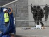 A worker puts up tarps on a temporary fence around the statue of the late Penn State football coach Joe Paterno before removing the statue outside Beaver Stadium in State College Pennsylvania