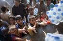 Iraqi people take water from a humanitarian aid convoy in Amerli on September 1, 2014