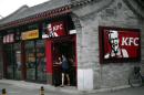 A woman holding an ice cream walks out of a KFC restaurant in Beijing