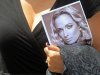 A woman holds a photo of Reeva Steenkamp, as she leaves her funeral,  in Port Elizabeth, South Africa, Tuesday, Feb. 19, 2013. Olympic athlete Oscar Pistorius is charged with the premeditated murder of Reeva Steenkamp on Valentine's Day. The defense lawyer says it was an accidental shooting. (AP Photo/Schalk van Zuydam)
