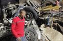 A man walks near a damaged vehicle after an explosion near a security building in Egypt's Nile Delta city of Mansoura