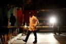 Forensic technician walks past a crime scene where five people were gunned down in Tegucigalpa