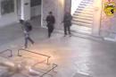 This frame grab from a video released by Tunisia's Interior Ministry shows the gunmen walking through the National Bardo museum during the attack that killed 21 people on Wednesday, March 18, 2015. The one-minute video posted on the ministry's Facebook page Saturday shows the two men walking through the museum, carrying assault rifles and bags. At one point they encounter another man with a backpack walking down a flight of stairs. They briefly acknowledge each other before they walk on in opposite directions. There was no explanation of who the third man was. (AP Photo/Tunisia's Interior Ministry)