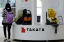 Visitor walks past displays of Takata Corp at a showroom for vehicles in Tokyo in this file photo