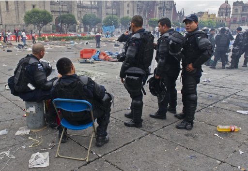 Mexican Federal Police take a rest in Mexico City's Zocalo square after clashes with teachers on September 13, 2013