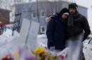 Azzedine Najd (R) and his wife Fadwa Achmaoui look at the memorial near the site of a fatal shooting at the Quebec Islamic Cultural Centre in Quebec City