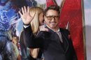 Cast member Robert Downey Jr. waves next to co-star Gwyneth Paltrow at the premiere of "Iron Man 3" in Hollywood