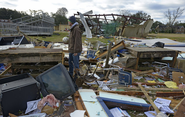 <p>               Murphy High School teacher Leland Howard tries to salvage items where his algebra classroom once stood in a temporary building at Murphy High School as residents clean up and assess the damage from a Christmas Day tornado Wednesday, Dec. 26, 2012  in Mobile, Ala. With only a handful of injuries and no deaths reported statewide from the storms, the head of the state's emergency response said it was difficult to fathom how the toll wasn't worse. (AP Photo/G.M. Andrews)