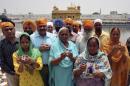 Relatives pose with the photographs of Indian workers, who have been kidnapped in Iraq, in front of the holy Sikh shrine, the Golden Temple, in Amritsar