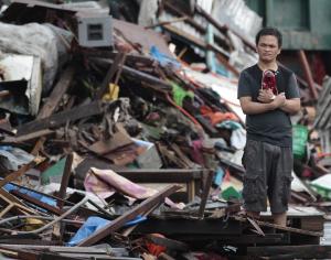 A resident looks at houses damaged by typhoon Haiyan, …